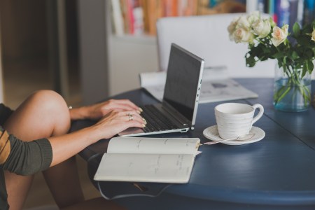 Woman sitting at a laptop tying