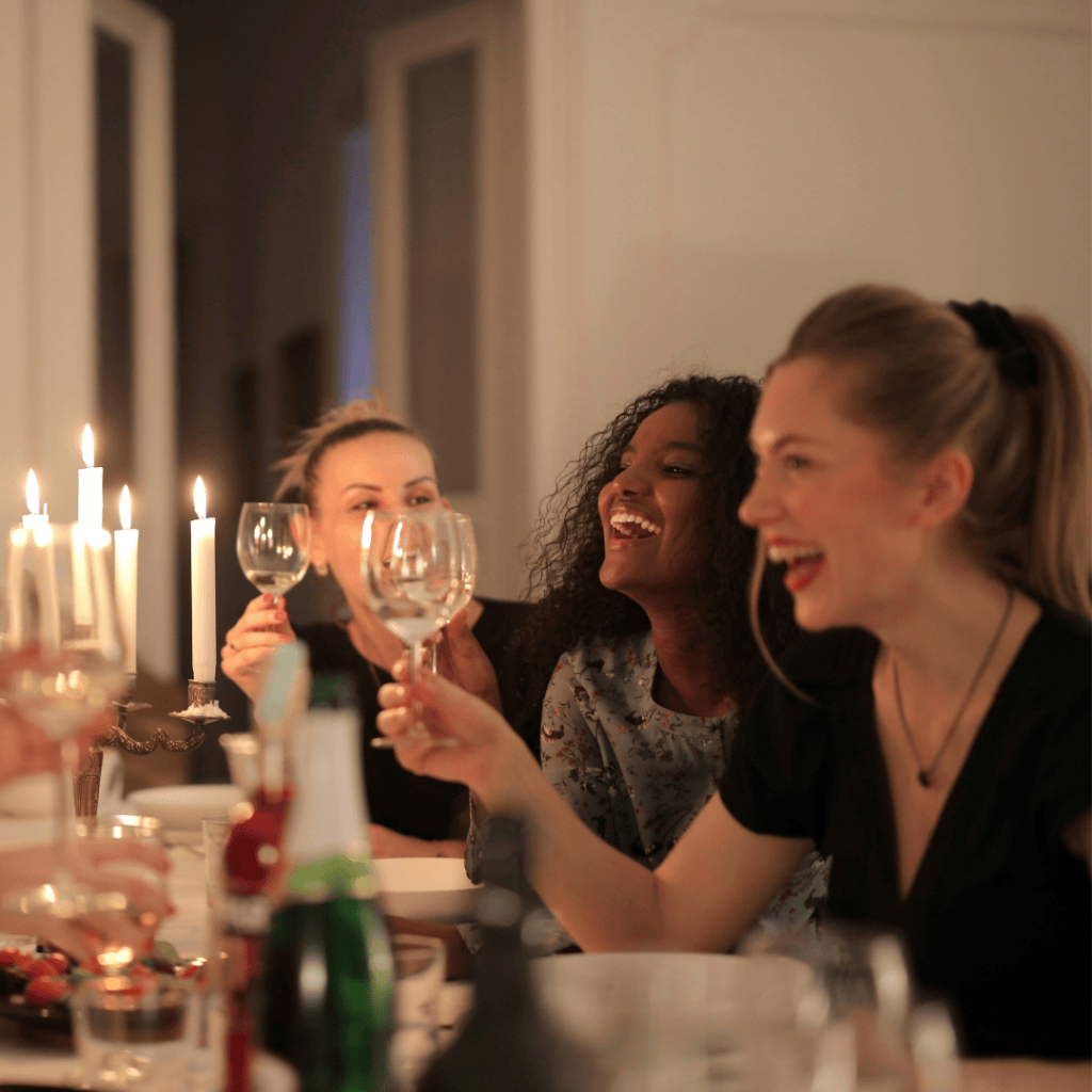 Group of women having dinner with wine and candles